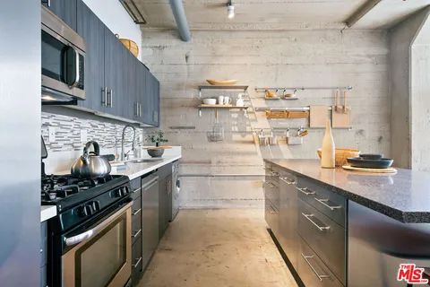 a kitchen with stainless steel appliances granite countertop a stove and a sink