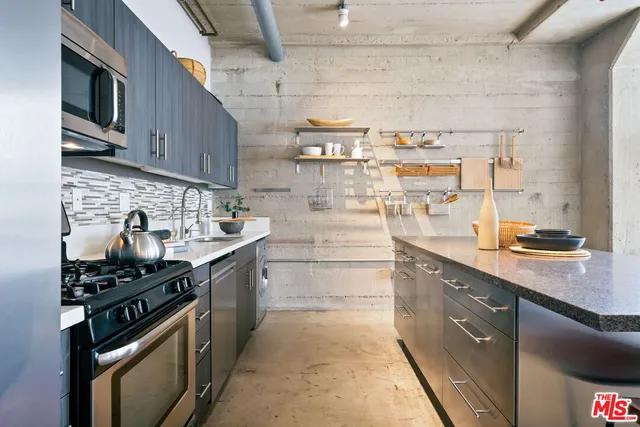 a kitchen with stainless steel appliances granite countertop a stove and a sink
