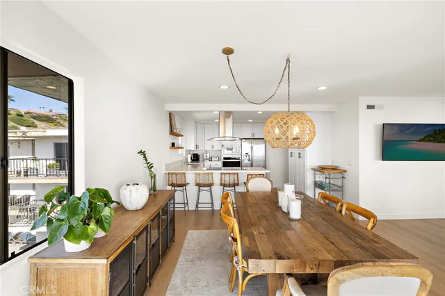 a view of a dining room with furniture a potted plant and wooden floor