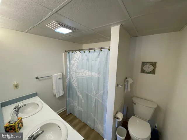 a white toilet sitting next to a bathroom sink and a shower