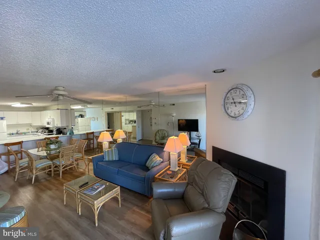 a living room with furniture a clock on wall and a window