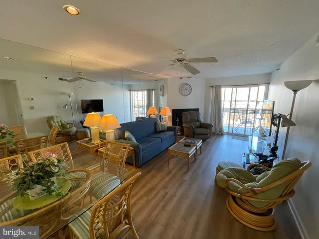 a living room with furniture a dining table and wooden floor