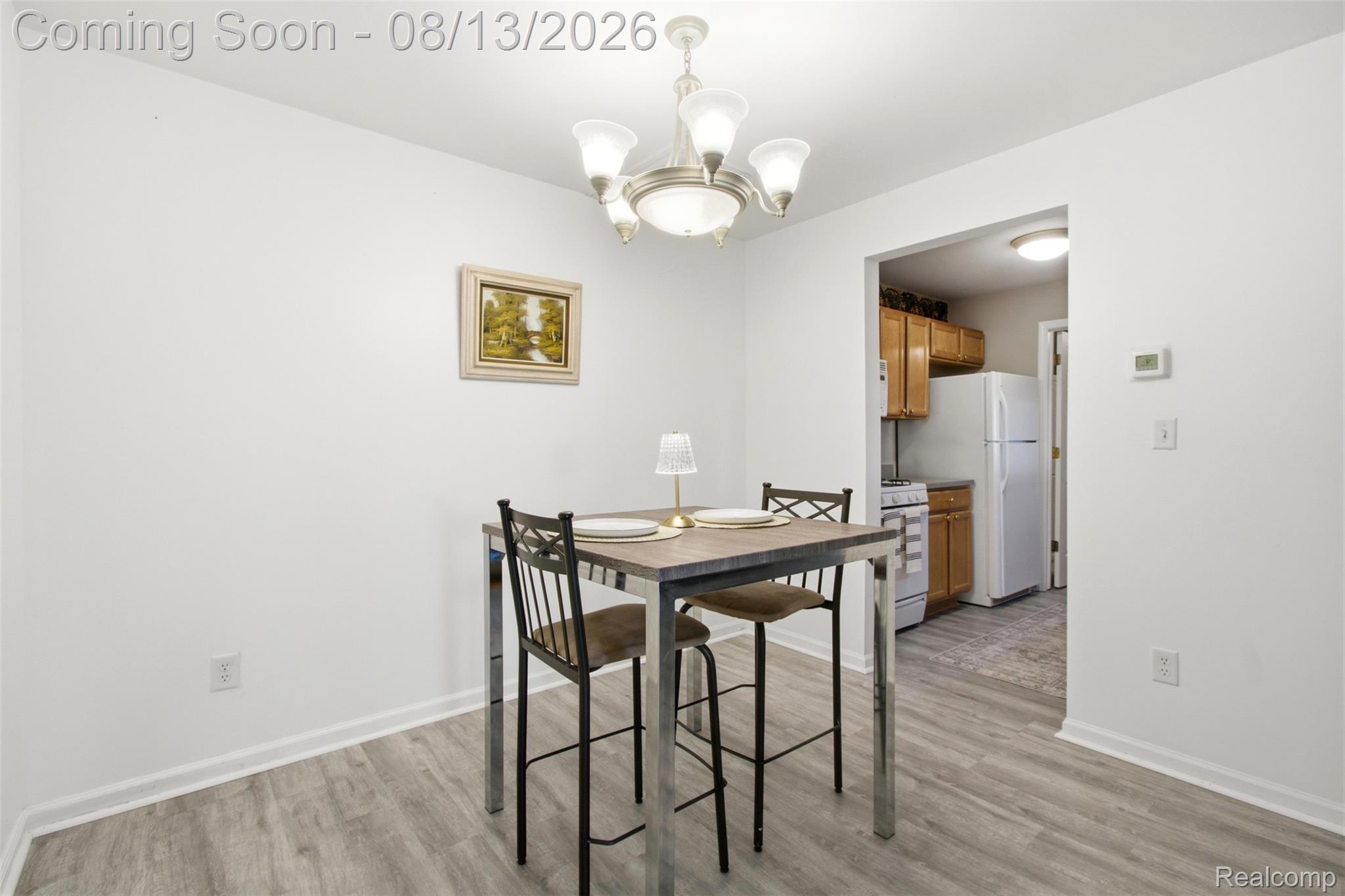 20656 Dunham Road, Unit 18 Clinton Township, MI 48038 - Photo 8 of 18 Dining area with wood-finish flooring and a multi-light chandelier