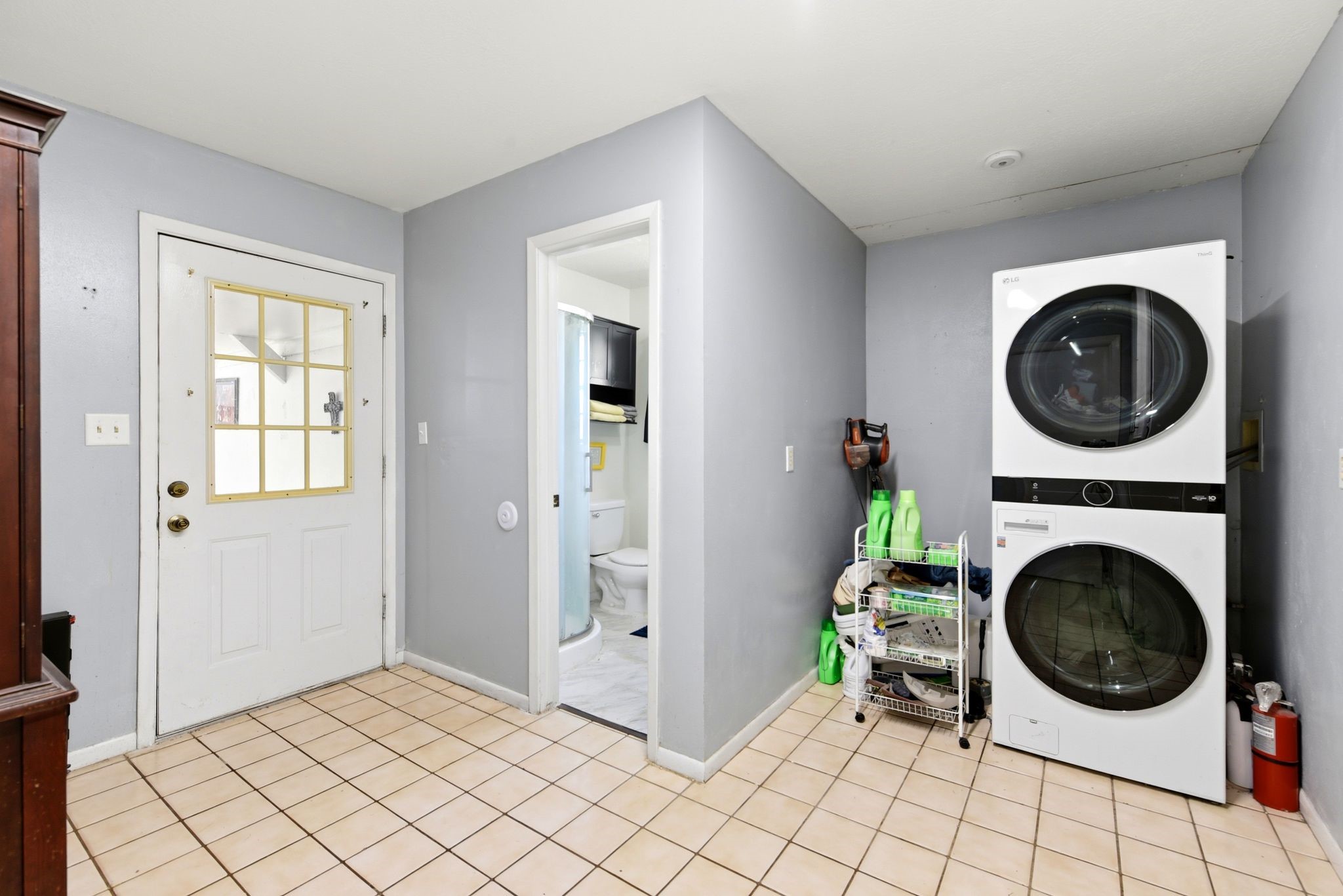 151 Parker Road New Waverly, TX 77358 - Photo 14 of 36 Convenient laundry room with modern stacked washer and dryer, ample storage, and easy access to an adjacent bathroom.
