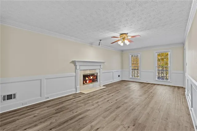 an empty room with windows and fireplace