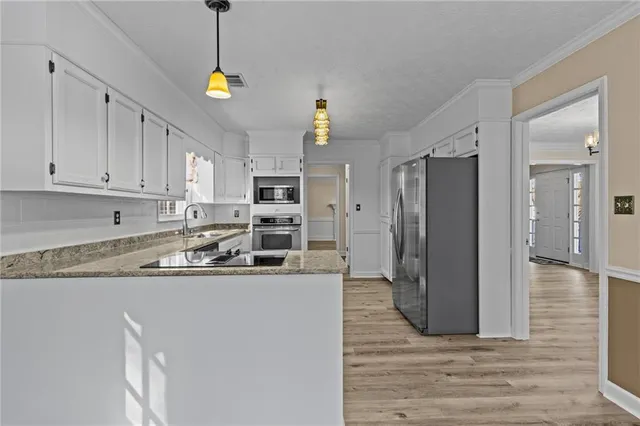 a kitchen with stainless steel appliances granite countertop a refrigerator a sink and a stove