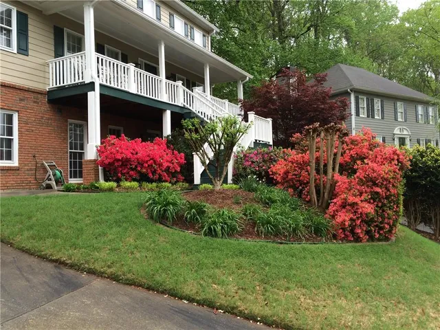 a view of a house with a big yard and potted plants