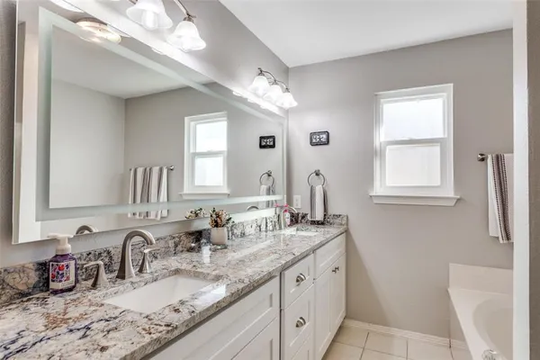 a bathroom with double vanity and a mirror