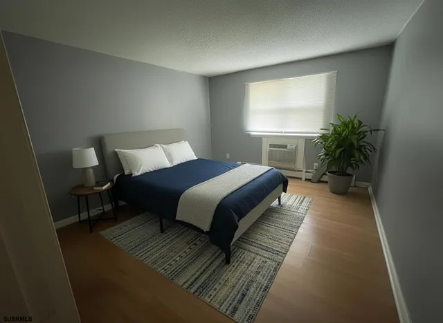 a bedroom with a bed lamp and a potted plant