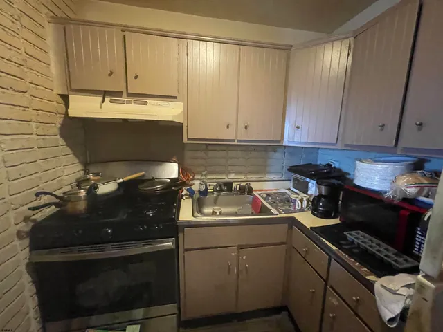 a kitchen with sink refrigerator and microwave