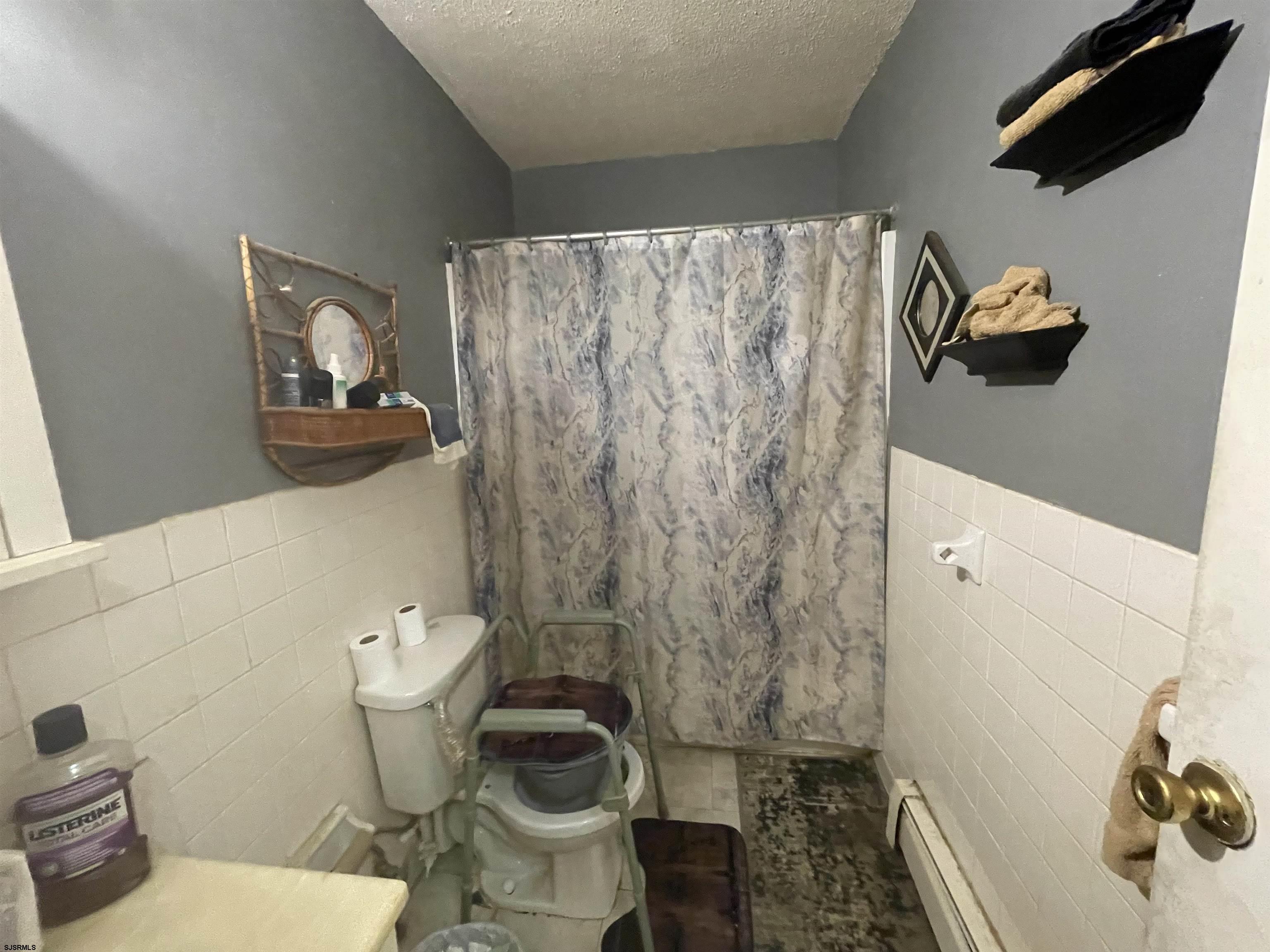 4901 Harbor Beach Boulevard, Unit F2 Brigantine, NJ 08203 - Photo 45 of 46 a white toilet sitting next to a shower curtain