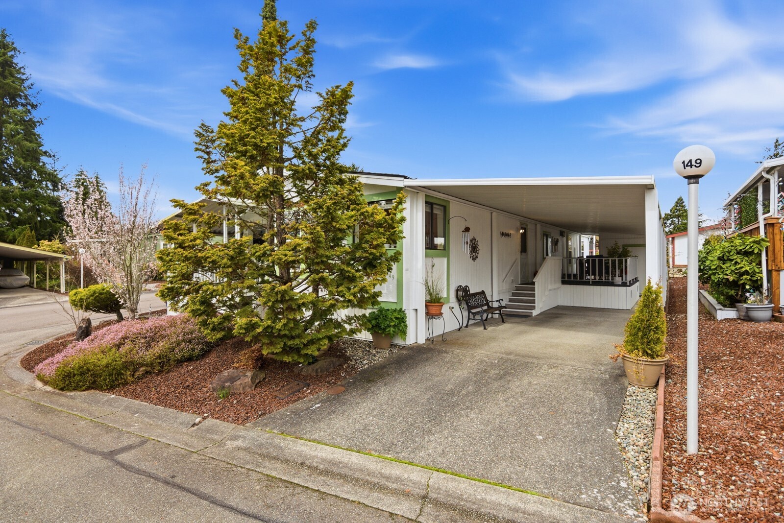 1427 100th Street Southwest, Unit 149 Everett, WA 98204 - Photo 31 of 40 a view of a house with potted plants and a pathway
