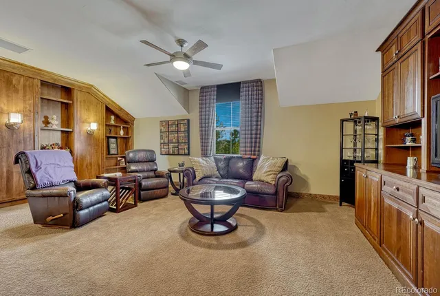 a living room with furniture and a book shelf