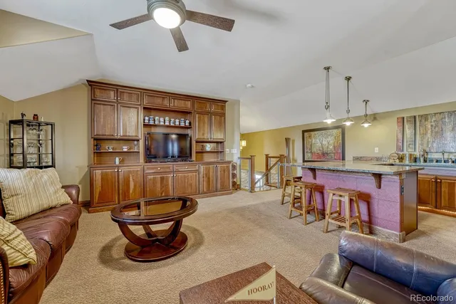 a living room with furniture a flat screen tv and kitchen view
