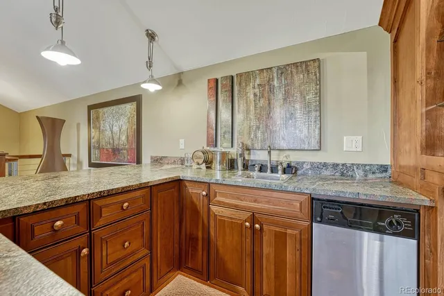 a kitchen with stainless steel appliances granite countertop wooden cabinets a sink and dishwasher with wooden floor