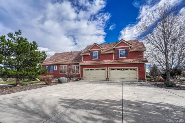 a view of a white house with a large tree