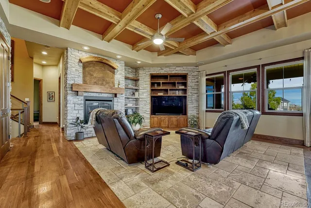 a living room with furniture a fireplace and a floor to ceiling window