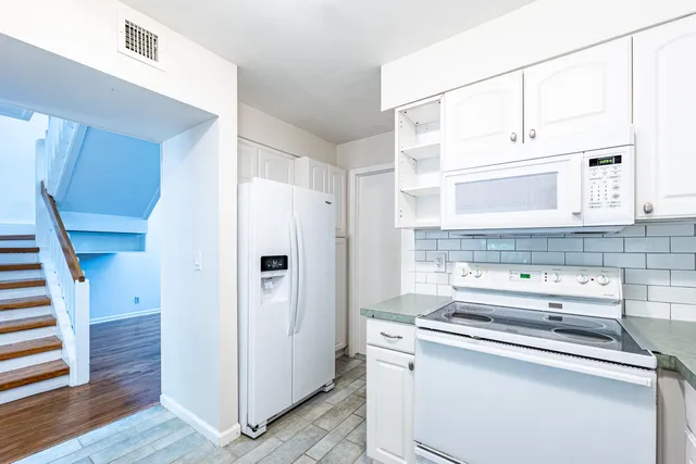 a bathroom with a granite countertop toilet sink and mirror