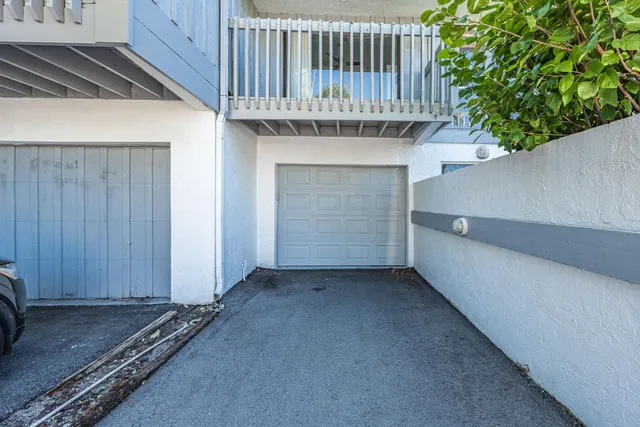 a view of a hallway with wooden floor and chandelier