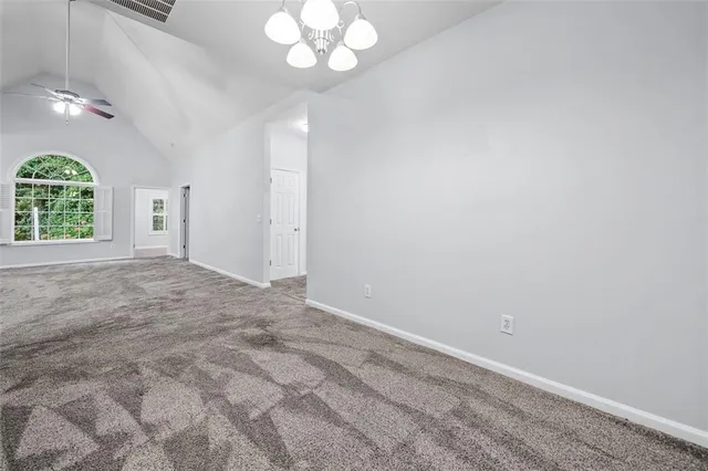 en empty room with windows and chandelier