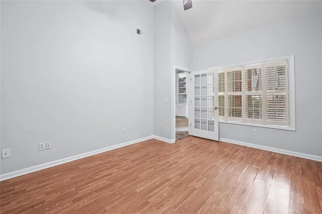 an empty room with wooden floor and windows