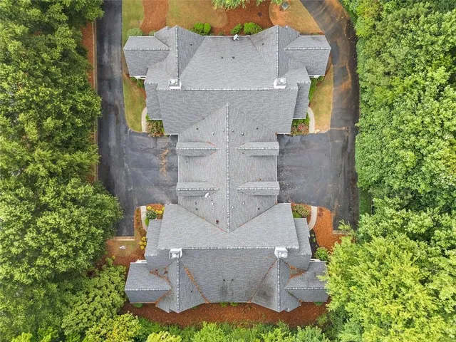 an aerial view of a house with yard and large trees