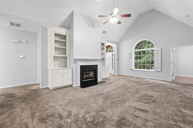 an empty room with windows and fireplace