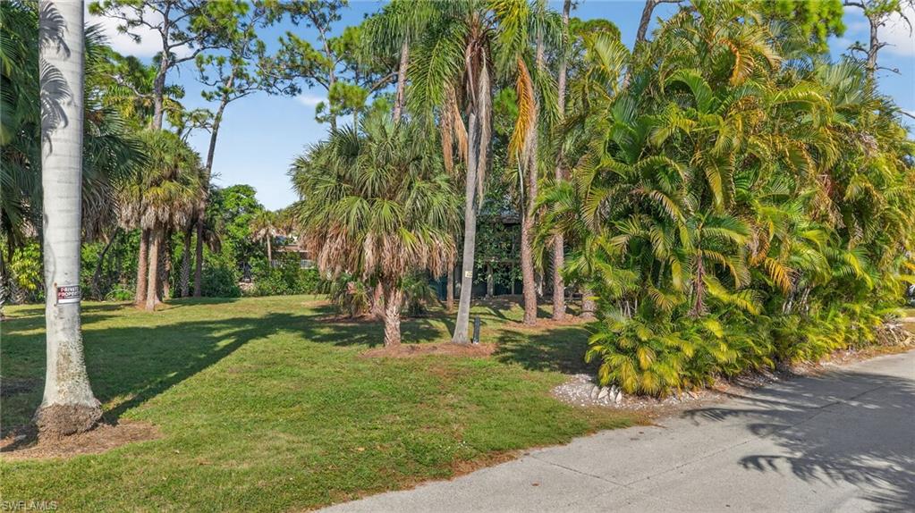 1675 Avion Place Naples, FL 34104 - Photo 2 of 18 a garden with trees in front of it