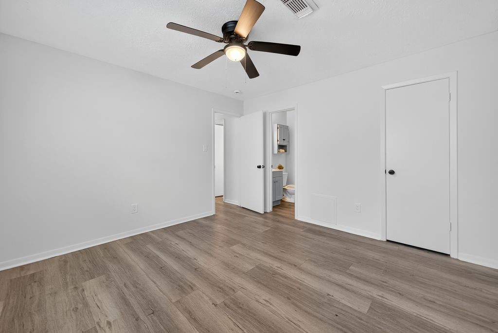 511 Bellmar Lane Friendswood, TX 77546 - Photo 11 of 29 an empty room with wooden floor ceiling fan and window