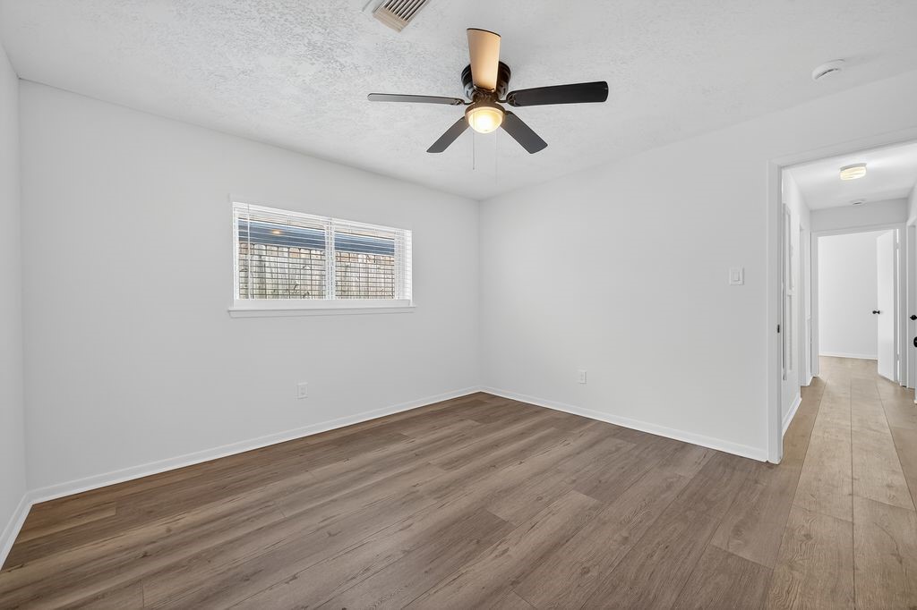 511 Bellmar Lane Friendswood, TX 77546 - Photo 12 of 29 wooden floor in an empty room with a window