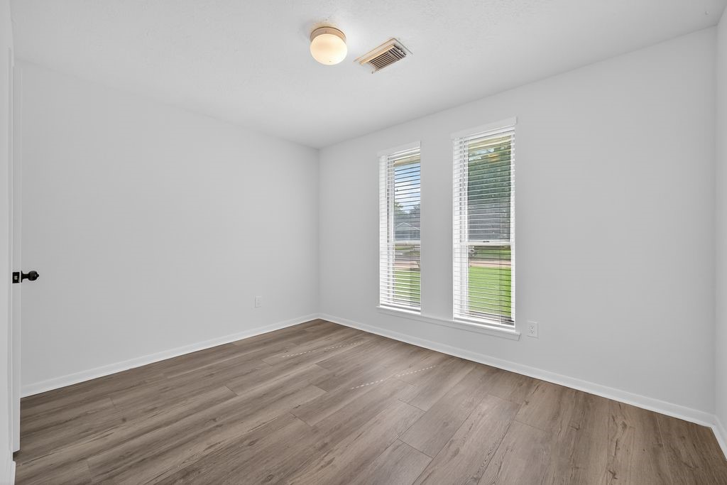 511 Bellmar Lane Friendswood, TX 77546 - Photo 16 of 29 an empty room with wooden floor and windows