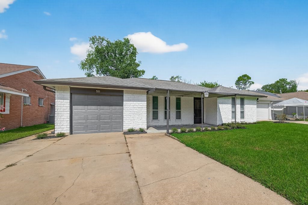 511 Bellmar Lane Friendswood, TX 77546 - Photo 3 of 29 a front view of a house with a garden and yard