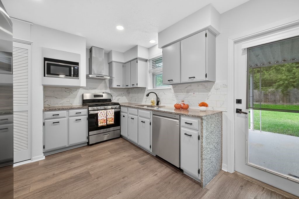 511 Bellmar Lane Friendswood, TX 77546 - Photo 7 of 29 a kitchen with cabinets stainless steel appliances and a window