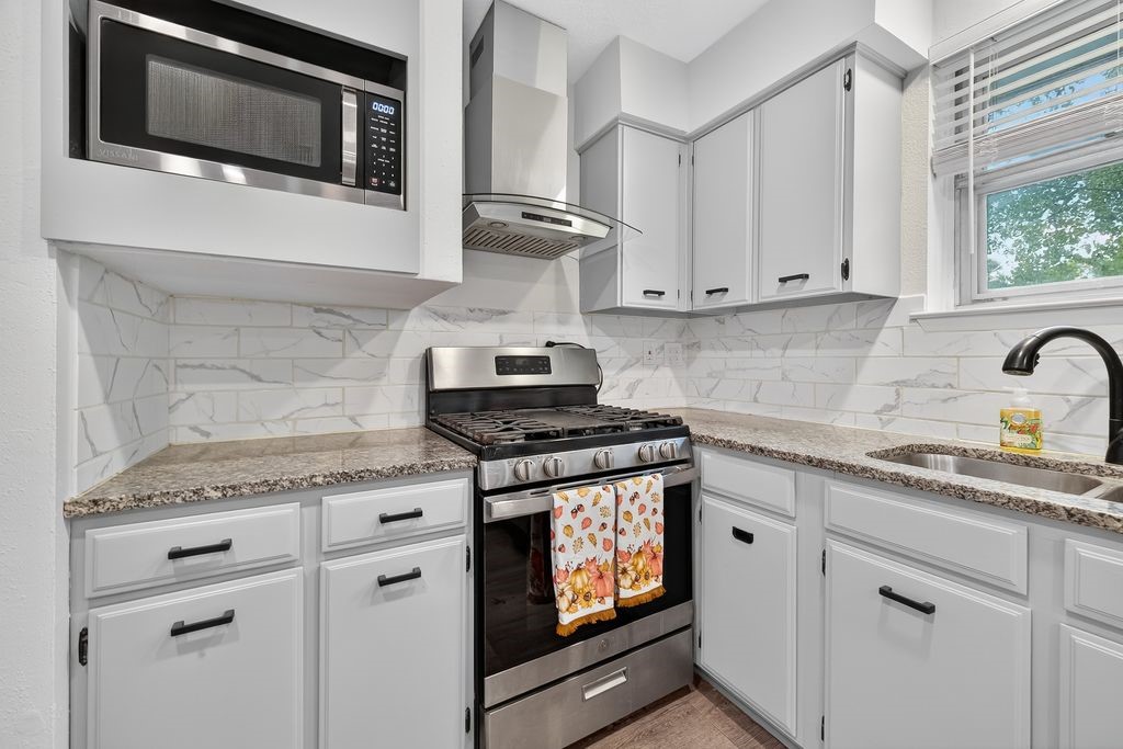 511 Bellmar Lane Friendswood, TX 77546 - Photo 8 of 29 a kitchen with granite countertop a stove and a sink