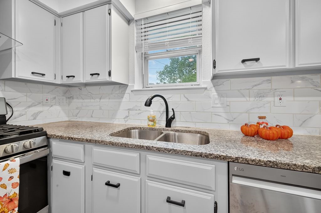 511 Bellmar Lane Friendswood, TX 77546 - Photo 9 of 29 a kitchen with granite countertop white cabinets and a sink