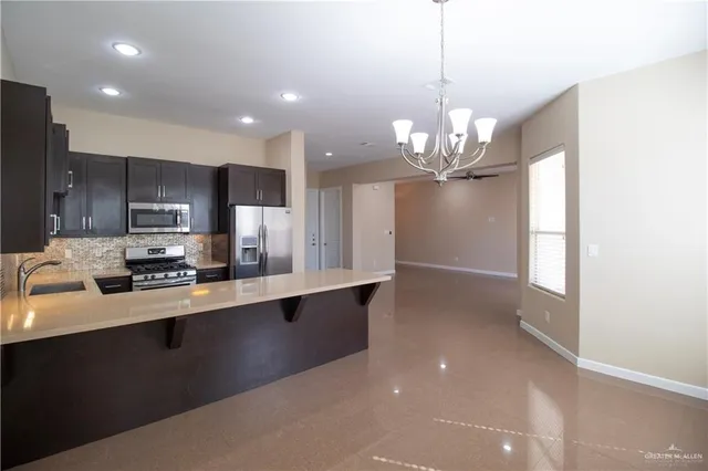 a kitchen with stainless steel appliances a sink stove and refrigerator