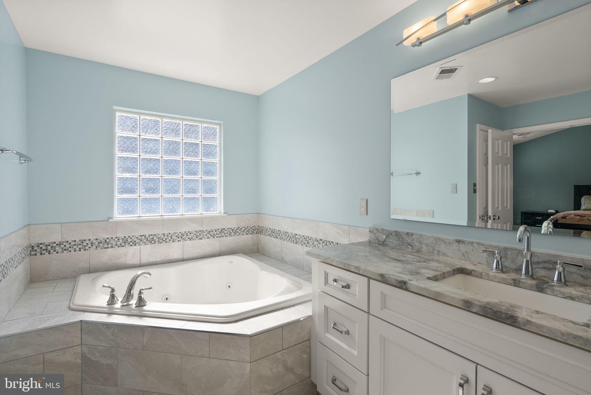 11477 Waterhaven Court Reston, VA 20190 - Photo 37 of 54 a bathroom with a granite countertop bathtub and a sink