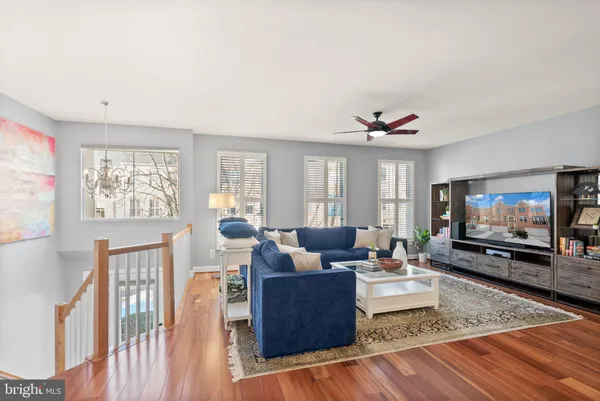 a living room with furniture a flat screen tv and wooden floor