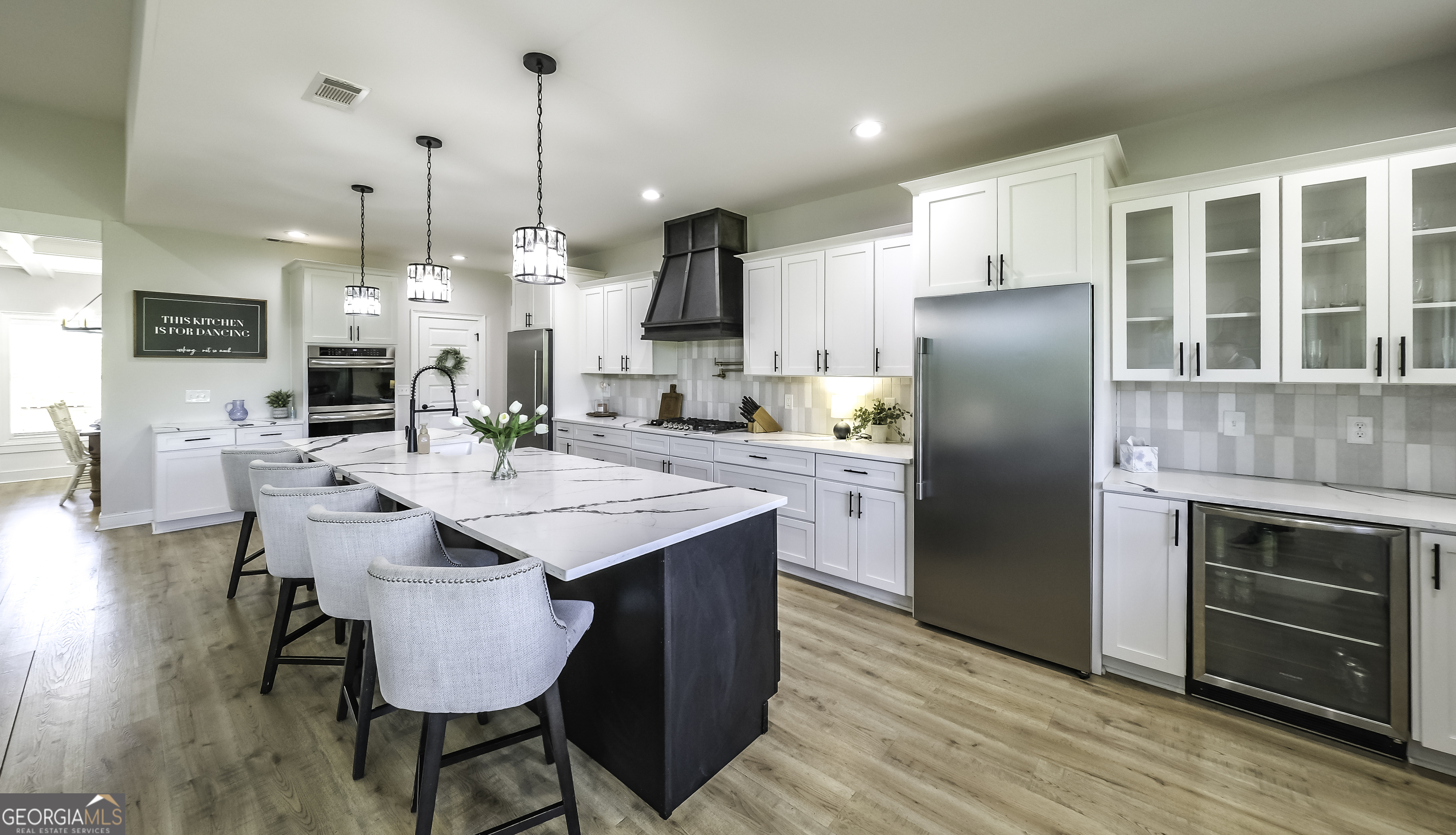 2392 Welcome Road Roopville, GA 30170 - Photo 9 of 43 a kitchen with stainless steel appliances kitchen island granite countertop a dining table chairs and a refrigerator