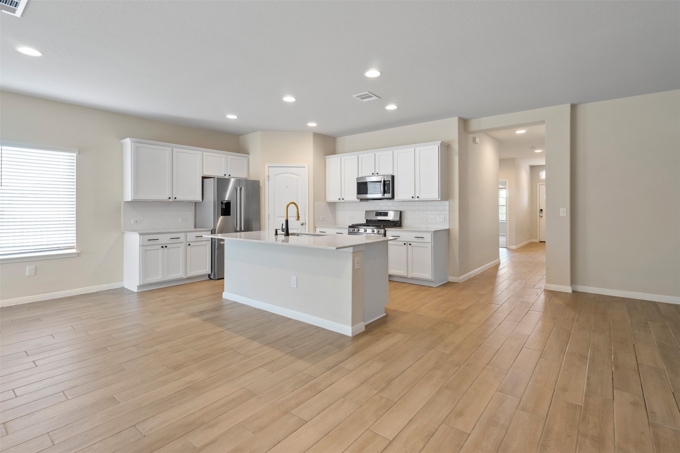 4125 Buffalo Ford Road Georgetown, TX 78628 - Photo 5 of 28 Kitchen with light countertops, light wood finished floors, stainless steel appliances, white cabinets, and recessed lighting