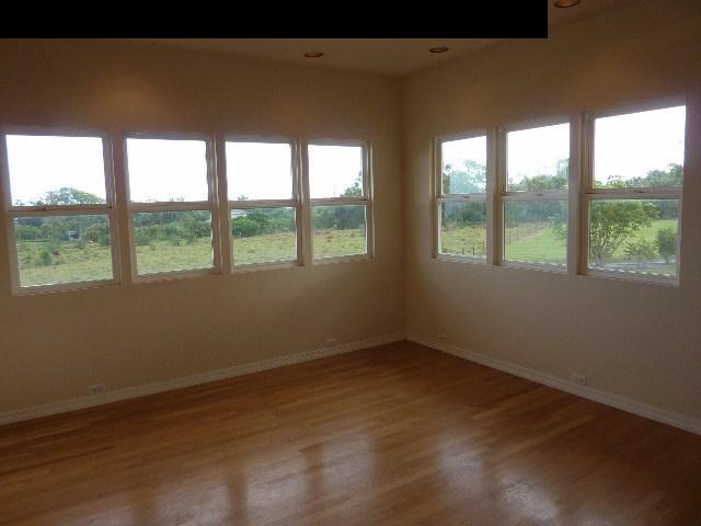 1454 Hog Back Road Haiku, HI 96708 - Photo 12 of 18 an empty room with wooden floor and windows
