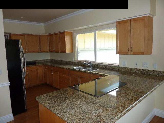 1454 Hog Back Road Haiku, HI 96708 - Photo 17 of 18 a kitchen with granite countertop a sink a stove and a refrigerator