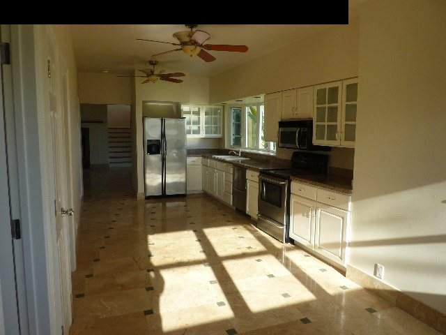 1454 Hog Back Road Haiku, HI 96708 - Photo 6 of 18 a kitchen with stainless steel appliances a stove a refrigerator and a sink