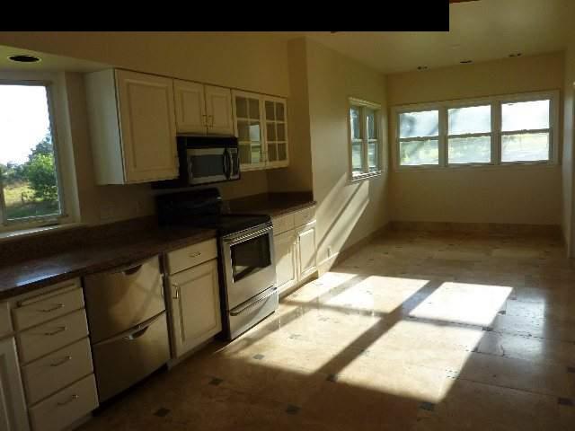 1454 Hog Back Road Haiku, HI 96708 - Photo 7 of 18 a kitchen with granite countertop a stove a sink and a microwave