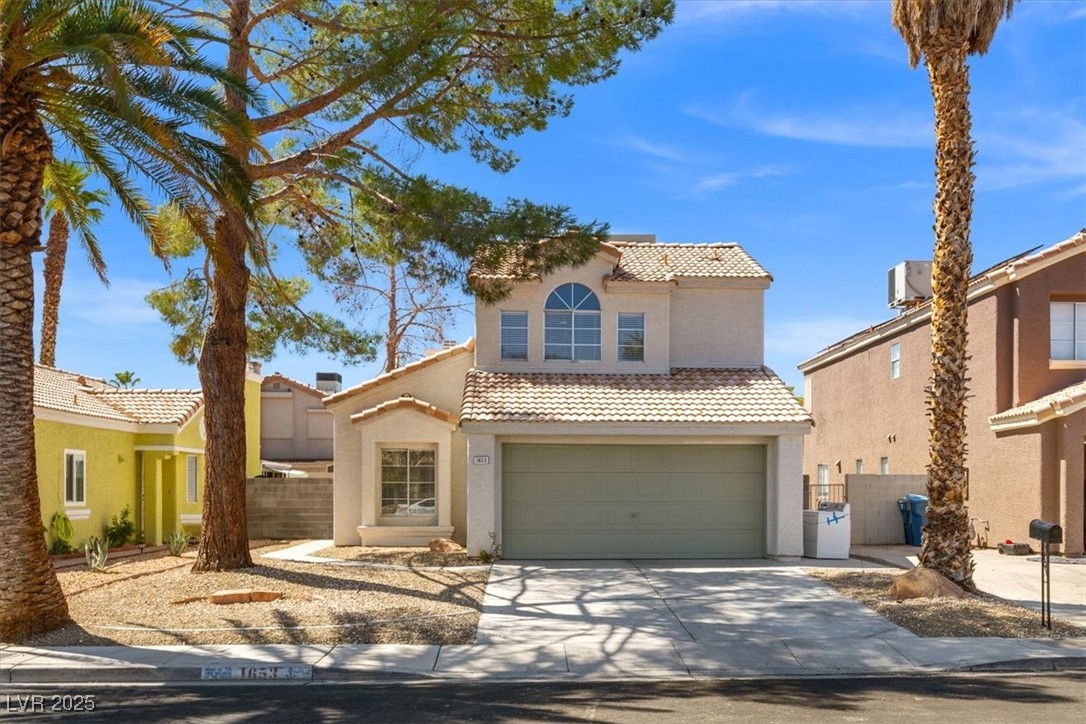 View of front of house featuring a tile roof, a garage, stucco siding, and driveway