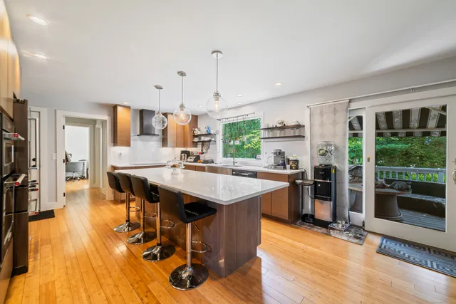 a open kitchen with stainless steel appliances granite countertop a stove and refrigerator a oven with wooden floors