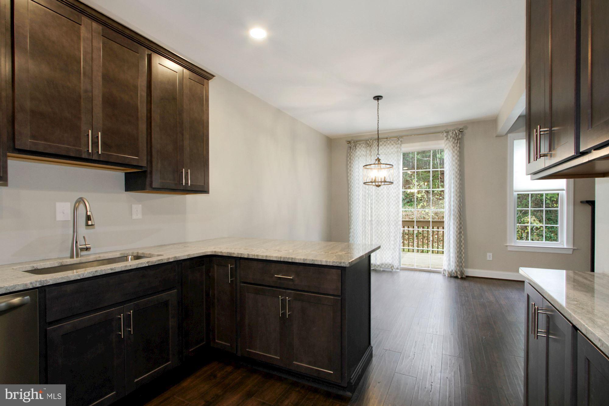 112 Federal Walk Kennett Square, PA 19348 - Photo 23 of 51 a kitchen with stainless steel appliances granite countertop wooden floors a sink and a window