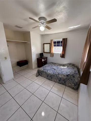 a bedroom with a bed and a ceiling fan