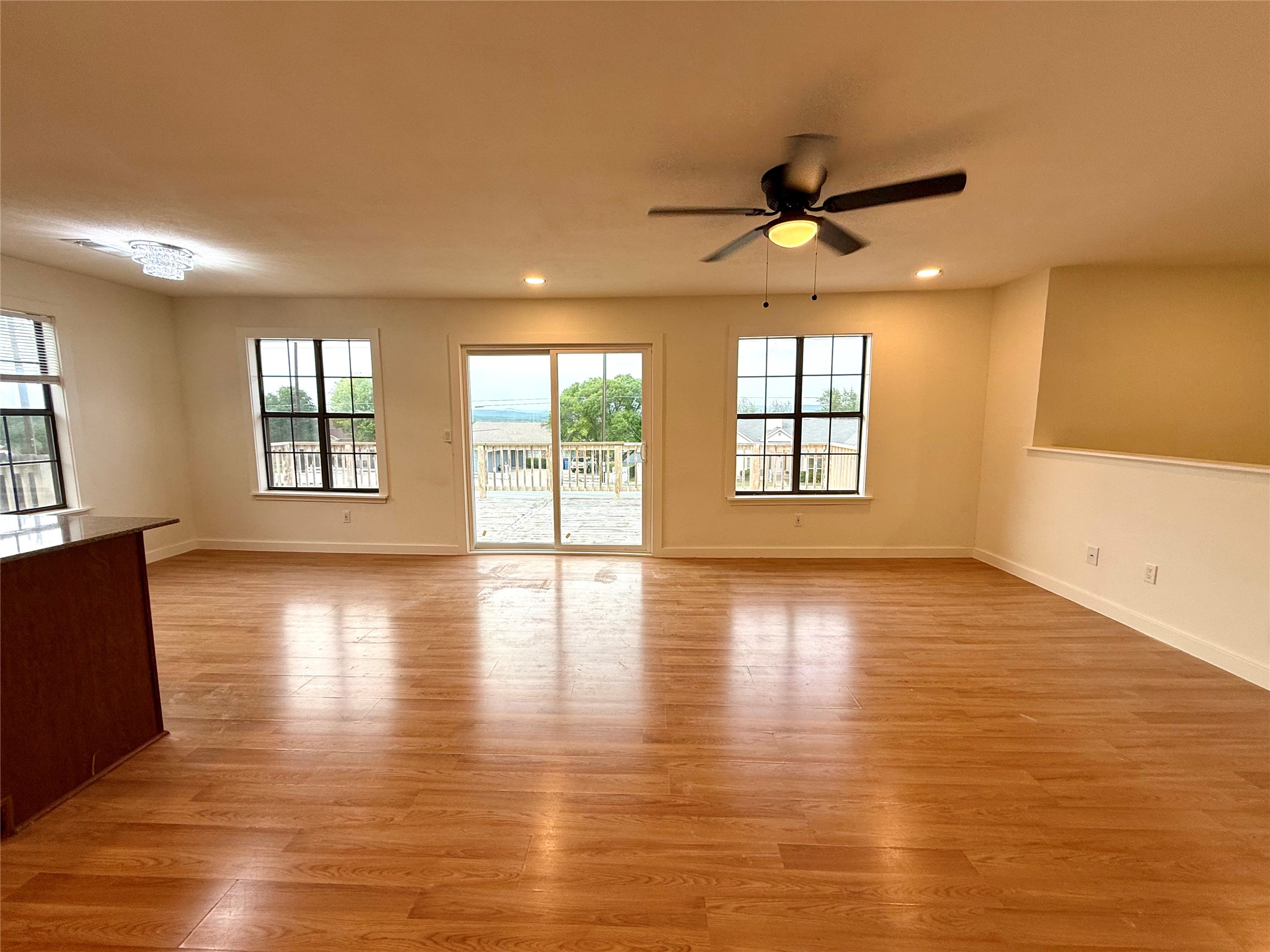 21003 Boggy Ford Road, Unit A Lago Vista, TX 78645 - Photo 14 of 19 an empty room with wooden floor and windows
