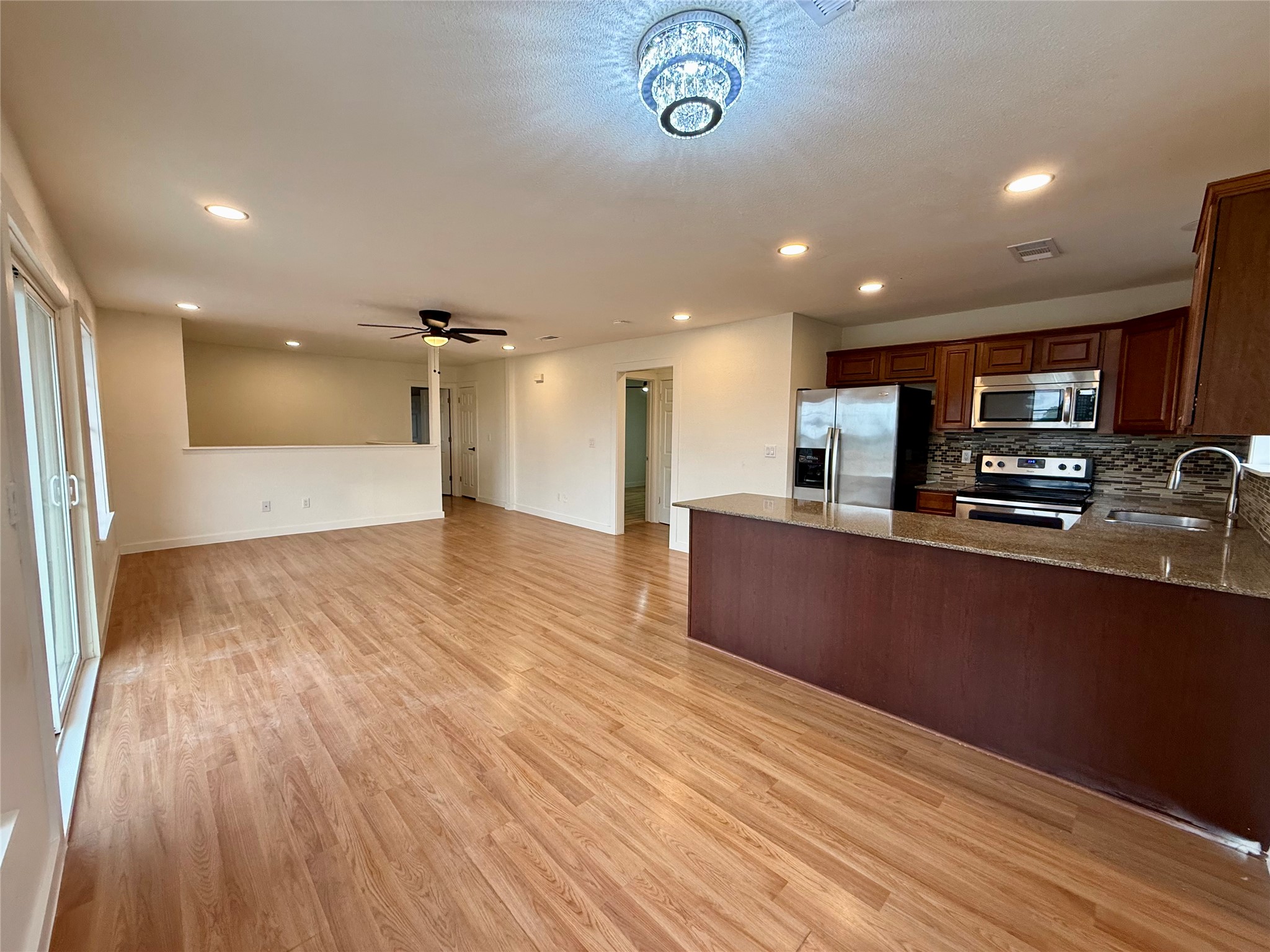 21003 Boggy Ford Road, Unit A Lago Vista, TX 78645 - Photo 2 of 19 a view of kitchen with kitchen island granite countertop wooden floors and stainless steel appliances